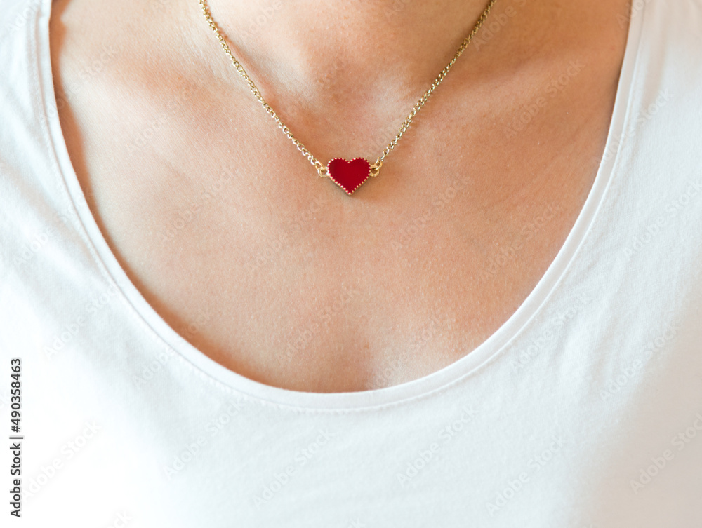 Closeup of girl with heart shape necklace.