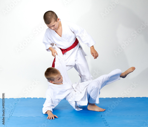 Athletes train judo throws on a blue mats