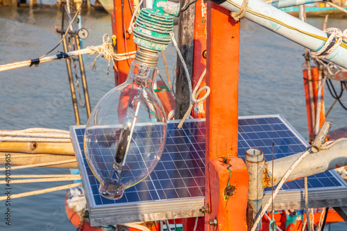 A halogen lamp with a solar battery charging station on the deck of a fisher boat