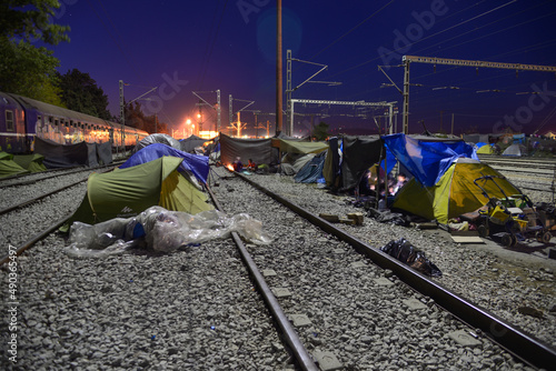 Long exposure of improvised tent city on railway tracks at night. Transit refugee/migrant camp at the Greek-North Macedonian border. People on the move stuck on their way to Western Europe. photo