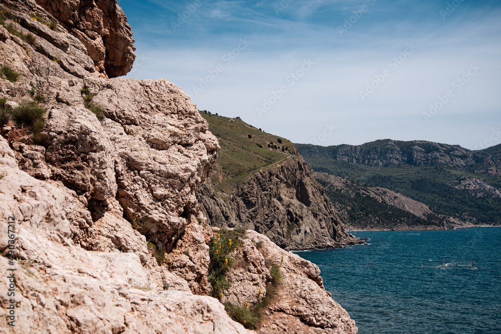 Rocky mountains on the background of the sea landscape. Coastline in summer.