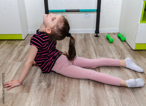 A little girl goes in for sports in her room.