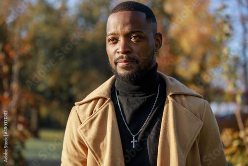 Handsome African - American man in trench coat, outdoor