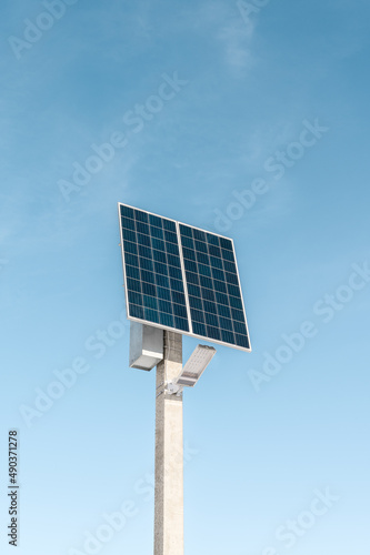 A street lighting system consisting of a solar panel and an LED lamp on blue sky background. Solar energy system, photovoltaic, alternative electricity source - concept of sustainable resource.