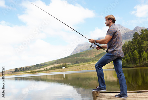 Its all about the right angle. Shot of a man holding a fishing rod in the outdoors.