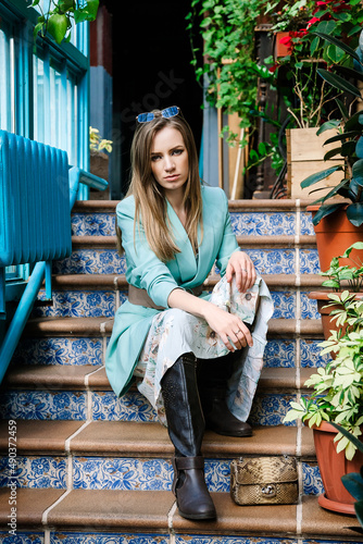 young attractive model with long blond hair posing on stairs indoors photo