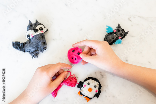 Child Hands Sewing Colorful Felt Animals photo