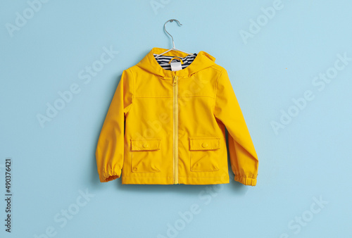 Child's raincoat hanging on blue wall