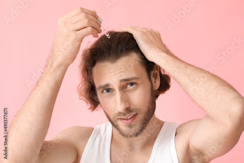 Young man using serum for h...