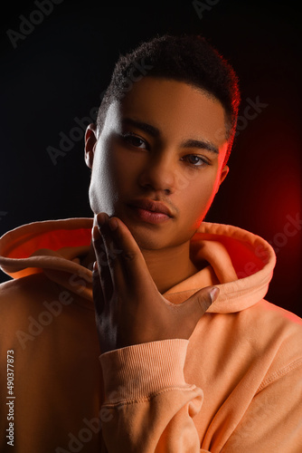 African-American teenage boy in hoodie on black background  closeup