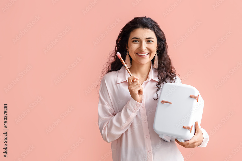 Young woman with small cosmetic refrigerator and brush on color background Young woman with small cosmetic refrigerator and brush on color background