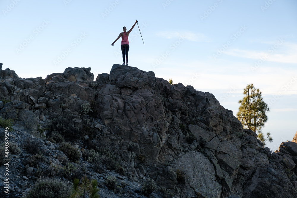 Happy woman hiking on top of the mountain