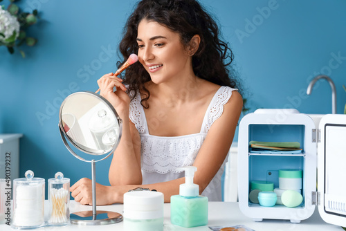 Young woman doing makeup ne...