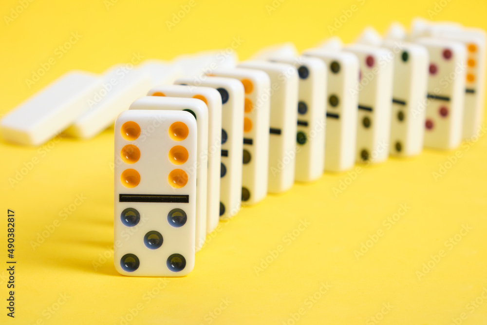 Domino knuckles on a yellow background, domino effect.
