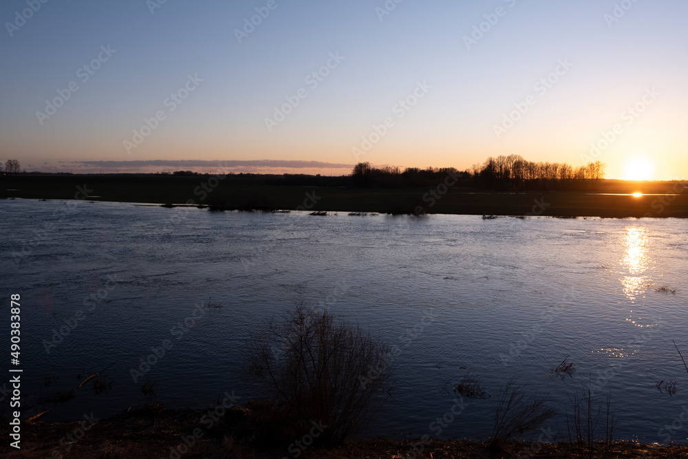 clear sky, golden sunset, winding river, purple clouds, spring evening near Lielupe river Latvia