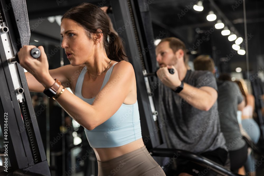 Determined woman on an exercise machine while working out in gym Determined woman on an exercise machine while working out in gym