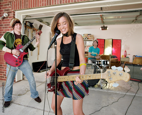 Group of Friends in garage band practicing in driveway in front of home  photo