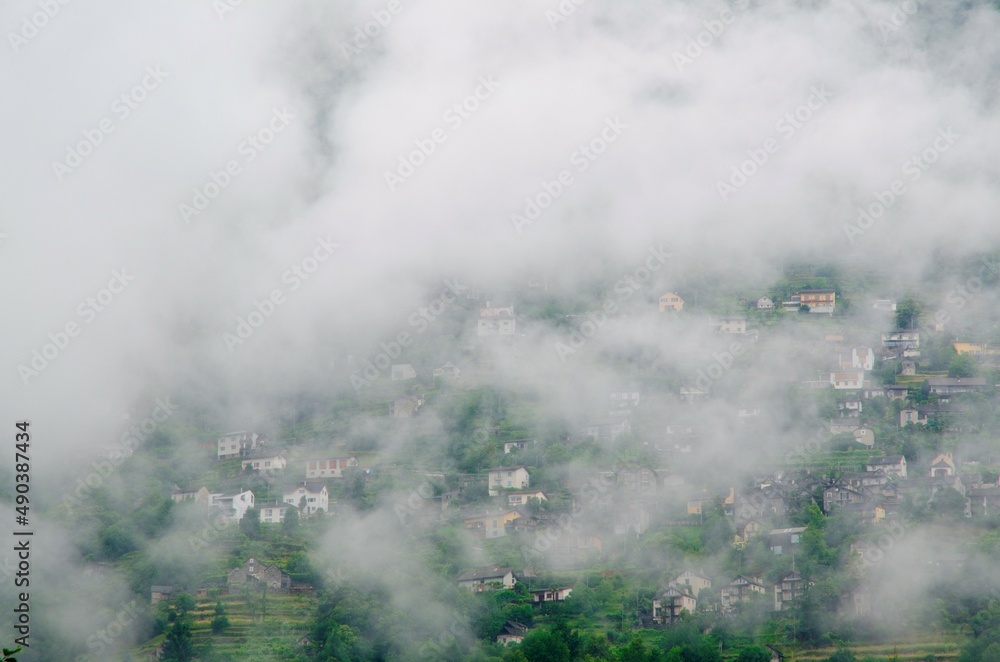 Alpine Village in Valley Verzasca in the Forest in the Mountain with Clouds in Ticino, Switzerland. Alpine Village in Valley Verzasca in the Forest in the Mountain with Clouds in Ticino, Switzerland.