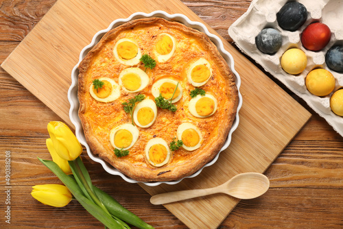 Tasty Easter tart, painted eggs and tulip flowers on wooden background
