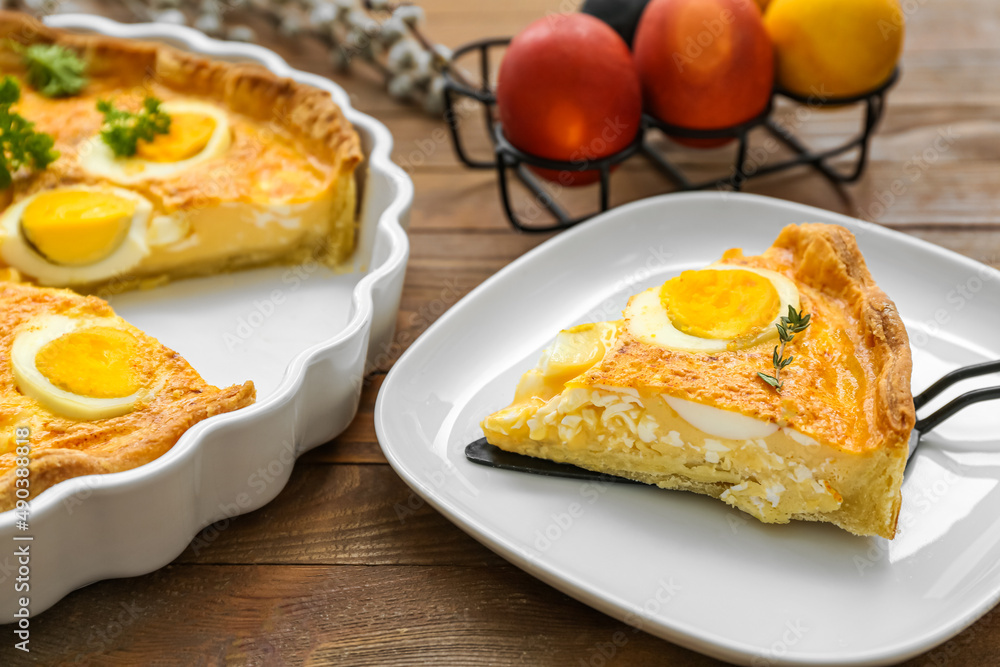 Plate with piece of tasty Easter tart with eggs on wooden background, closeup Plate with piece of tasty Easter tart with eggs on wooden background, closeup