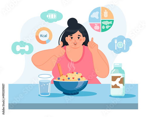 A happy obese woman is sitting at the table with a plate of porridge