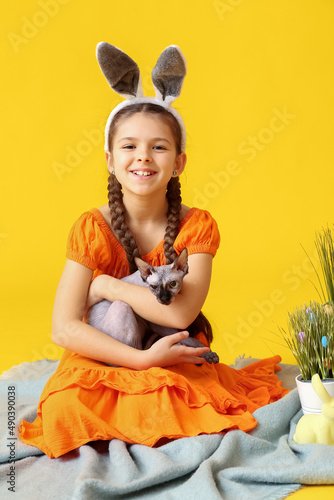 Little girl in bunny ears w...