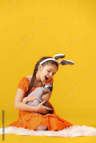 Little girl in bunny ears w...