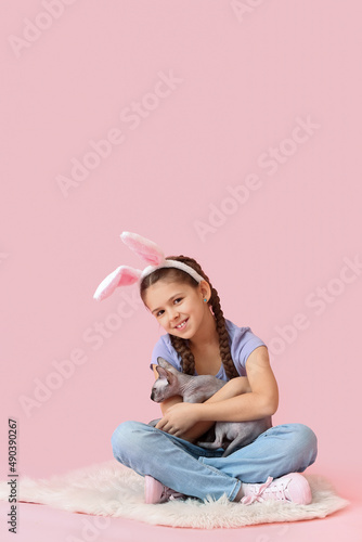 Little girl in bunny ears w...