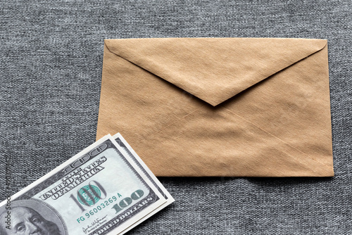 Hundred-dollar American banknotes at the envelope on a gray background and copy space. Refusal to bribe American bills.