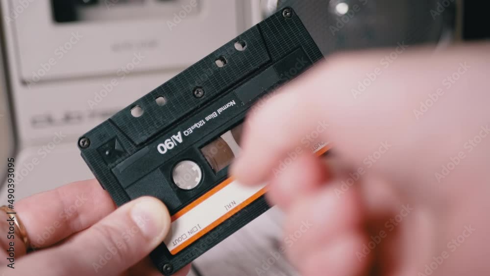 Female Rewinds a Tape with Finger on Old Vintage Audio