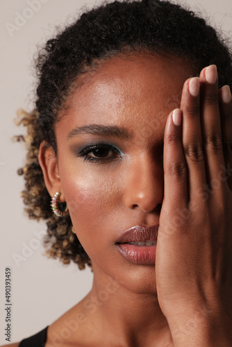 Vertical beautiful African American young woman with curly hair posing on white.