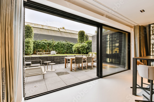 Fotografia Attractive huge sliding glass door leading to the courtyard