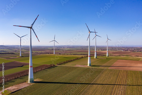 Luftaufnahme von mehreren Windkraftanlagen mit Windrädern zur Erzeugung von grüner Energie Rheinland-Pfalz, Deutschland
Drohnenaufnahme eines Winparks mit hohen Winkraftanlagen in der Wintersonne
