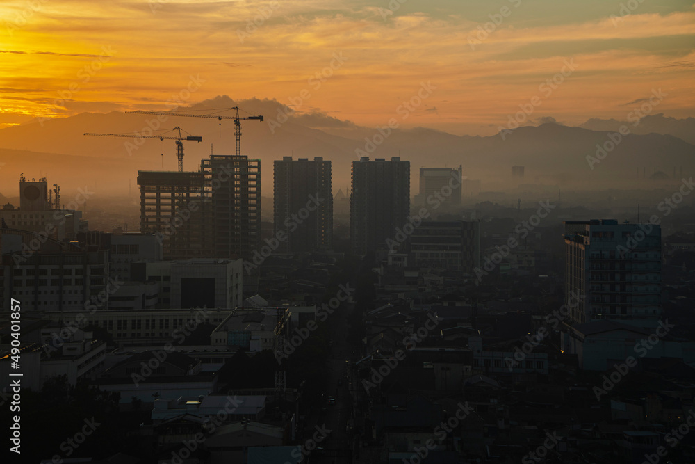 Foggy city view in the morning with beautiful sun shining in Bandung, Indonesia