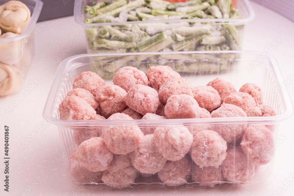 Containers with semi-finished meat products from the refrigerator. meatballs, dumplings, chopped beans Containers with semi-finished meat products from the refrigerator. meatballs, dumplings, chopped beans