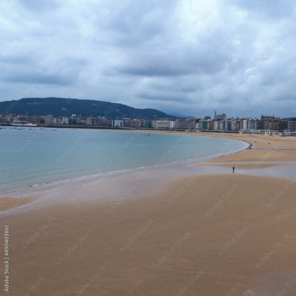 wide sandy beach, calm sea, cloudy sky. San Sebastian. Spain