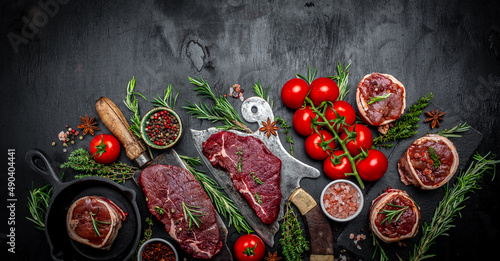Variety of raw black angus prime meat steaks beef rump steak, Tenderloin fillet mignon for grilling on old meat cleaver on dark background. Long banner format. top view