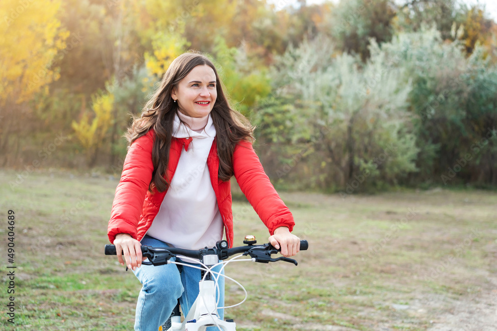 Naklejka premium Portrait of a happy smiling woman riding a bicycle on the outdoor. Active sporty people concept image