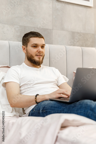 young man at home on sofa with laptop