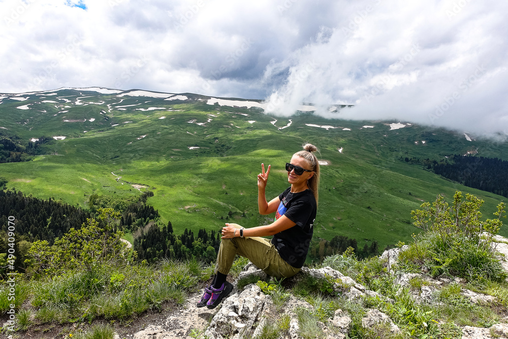 Naklejka premium A girl on the background of alpine meadows of the Lago-Naki plateau in Adygea. Russia. 2021.