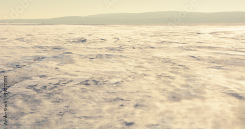 Frozen Onego lake with snow dust from the strong wind