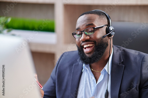 Representive African American practitioner leads online training wearing a suit and headset, active gestures and explanations