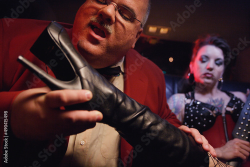 Dominatrix putting boot in man's face photo