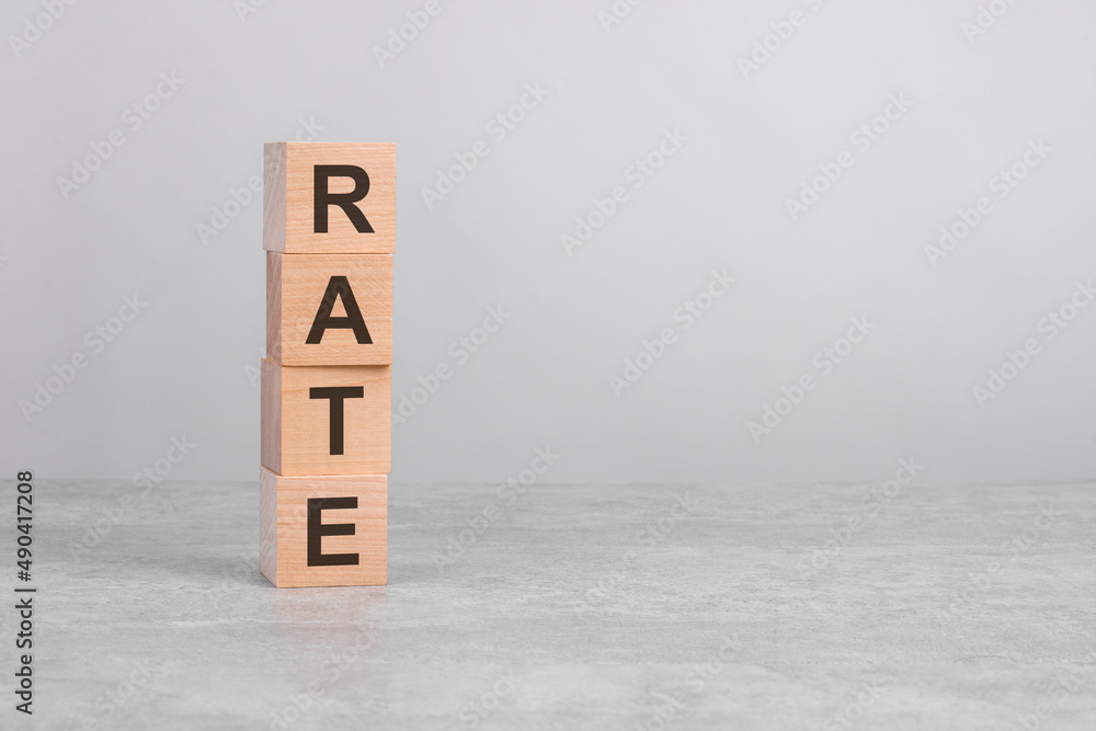 wooden cube on a concrete surface with text Rate. copy space on right for design, gray background wooden cube on a concrete surface with text Rate. copy space on right for design, gray background