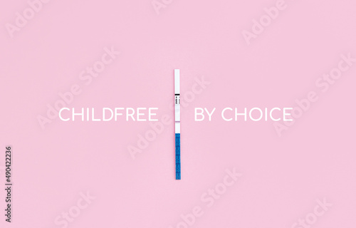 Pregnancy test with negative result and phrase Childfree by choice on pink background. Childlessness concept, copy space photo