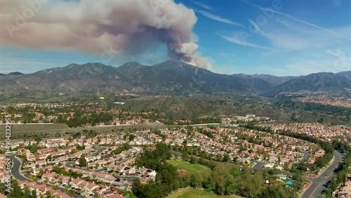A panning aerial view of a fire in the Santa Ana Mountains from Mission Viejo, California photo