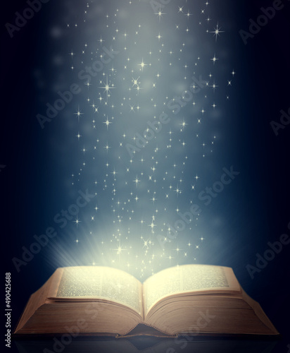 Be drawn into new worlds. Shot of an open storybook with light emanating from it. photo