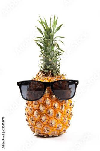 Ripe pineapple with sunglasses on yellow background