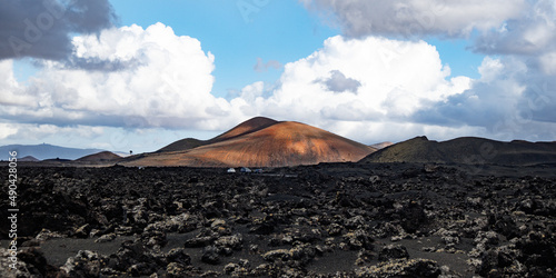 Amazing panoramic landscape of volcano craters in Timanfaya national park. Popular touristic attraction in Lanzarote island, Canary islans, Spain. Artistic picture. Beauty world. Travel concept.
