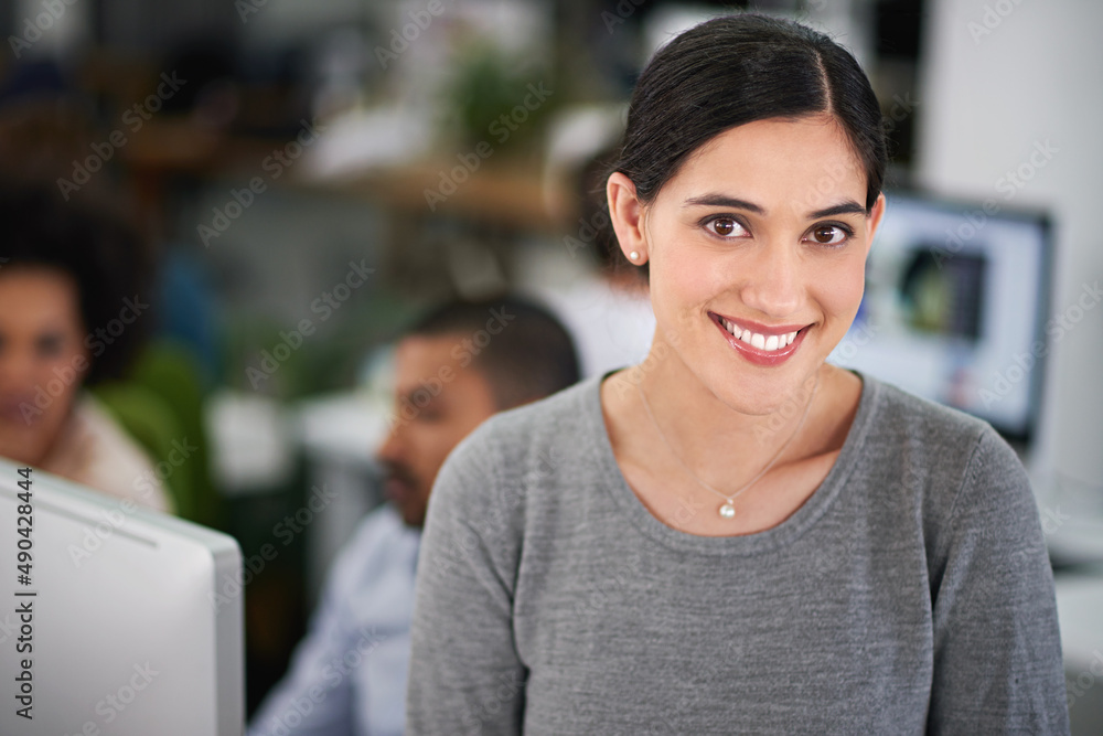 Shes got business accumen. Cropped shot of an attractive young businesswoman sitting on her desk with a few coworkers in the background. Shes got business accumen. Cropped shot of an attractive young businesswoman sitting on her desk with a few coworkers in the background.